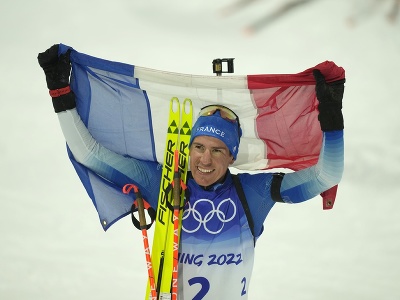 Francúzsky biatlonista Quentin Fillon Maillet máva francúzskou vlajkou po zisku zlatej olympijskej medaily v stíhacích pretekoch mužov na 12,5 km