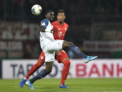 Hráč Bochumu Silvere Ganvoula Mboussy (vľavo) bojuje o loptu s Jeromem Boatengom z Bayernu