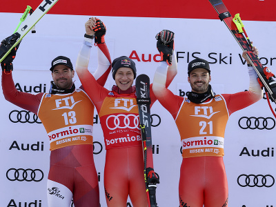 Švajčiarsky lyžiar Marco Odermatt (uprostred) sa teší na pódiu po triumfe v super-G mužov Svetového pohára v alpskom lyžovaní v talianskom stredisku Bormio. Druhý skončil Rakúšan Vincent Kriechmayr (vľavo). Tretí skončil ďalší Helvét Loic Meillard