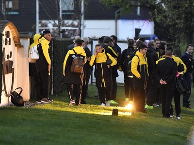 Hráči Dortmundu stoja neďaleko poškodeného autobusu po bombovom útoku v Dortmunde