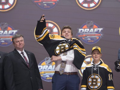 Charlie McAvoy si oblieka dres Bostonu Bruins