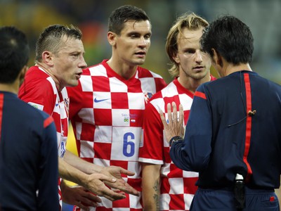 Ivan Rakitič (vpravo) sa u japonského rozhodcu so spoluhráčmi sťažuje na nesprávny penaltový verdikt