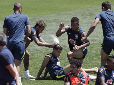 Brazílski futbalisti Neymar (vľavo) a Gabriel Jesus hádžu múku a vajíčka na hlavu spoluhráča Philippe Coutinha, ktorý oslavuje svoje narodeniny počas tréningu v Soči