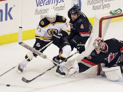 Aaron Ward a brankár Cam Ward útočia na Michaela Rydera