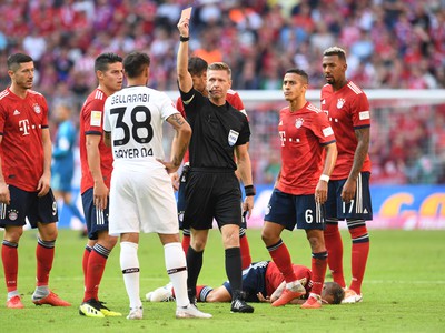 Rozhodca Tobias Welz (uprostred) ukazuje červenú kartu Karimu Bellarabimu z Leverkusenu po zákroku na obrancu Rafinhu z Bayernu Mníchov