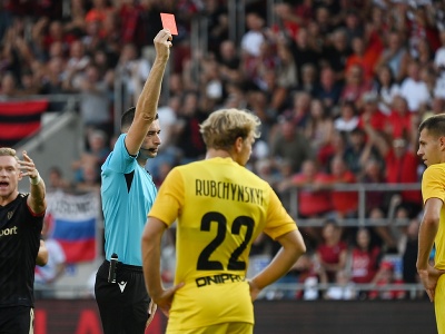 Na snímke uprostred albánsky hlavný rozhodca Juxhin Xhaja udeľuje červenú kartu, vpravo jej adresát a hráč Dnipra Eduard Sarapij v piatej minúte v prvom zápase play off Európskej konferenčnej ligy
