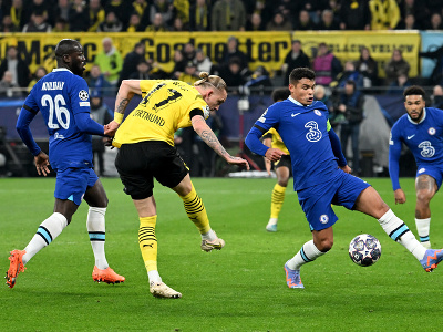 Hráč Dortmundu Marius Wolf (uprostred) kope do lopty cez Thiaga Silvu z Chelsea