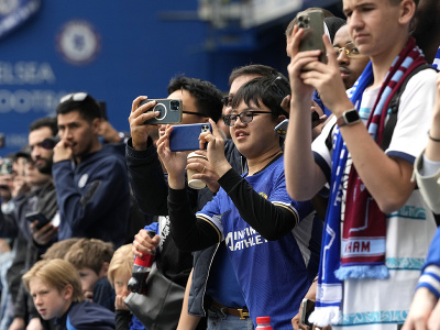 Futbaloví fanúšikovia fotia mobilnými telefónmi pred zápasom 36. kola Premier League FC Chelsea - West Ham United