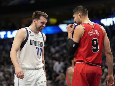 Basketbalista Dallasu Mavericks Luka Doncič (vľavo) a hráč Chicaga Bulls Nikola Vučevič sa rozprávajú na palubovke počas zápasu zámorskej basketbalovej NBA 
