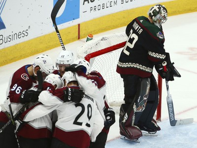 Hráči Colorada Avalanche oslavujú gól a v pozadí je brankár Arizony Coyotes Antti Raanta.