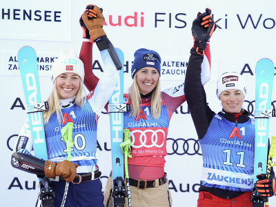 Víťazná rakúska lyžiarka Cornelia Hütterová (uprostred) oslavuje na pódiu s druhou Nórkou Kajsou Vickhoffovou Lieovou (vľavo) a treťou Švajčiarkou Larou Gutovou-Behramiovou