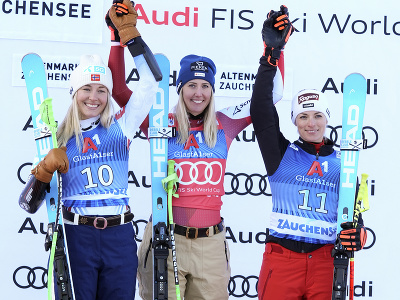 Víťazná rakúska lyžiarka Cornelia Hütterová (uprostred) oslavuje na pódiu s druhou Nórkou Kajsou Vickhoffovou Lieovou (vľavo) a treťou Švajčiarkou Larou Gutovou-Behramiovou 