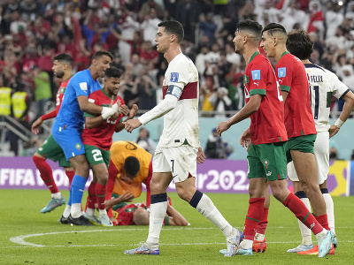 Marockí hráči oslavujú po výhre nad Portugalskom, zatiaľčo čo portugalský hráč Cristiano Ronaldo (uprostred) sklamaný odchádza z ihriska