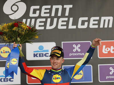 Dánsky cyklista Mads Pedersen oslavuje na pódiu po jeho víťazstve nedeľňajšej flámskej klasiky Gent - Wevelgem v belgickom meste Wevelgem