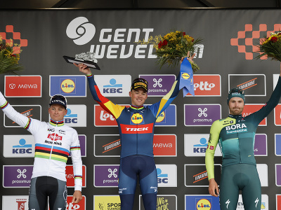 Víťazný dánsky cyklista Mads Pedersen (uprostred) oslavuje na pódiu s druhým Holanďanom Mathieuom Van Der Poelom (vľavo) a tretím Belgičanom Jordim Meeusom (vpravo) po pretekoch nedeľňajšej flámskej klasiky Gent - Wevelgem