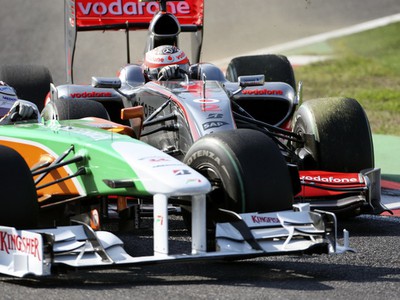 Jazdec Force India Adrian Sutil v tesnej blízkosti Hekkiho Kovalainena jazdca MsLarenu