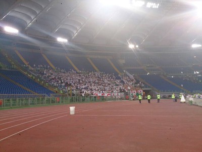 Fanúšikovia Legie Varšava na štadióne Lazia Rím. Okolo nich prázdne tribúny, aby nedošlo k stretu a bitkám