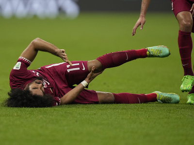Katarský futbalista Akram Afif leží na zemi po faule vo finále Ázijského pohára