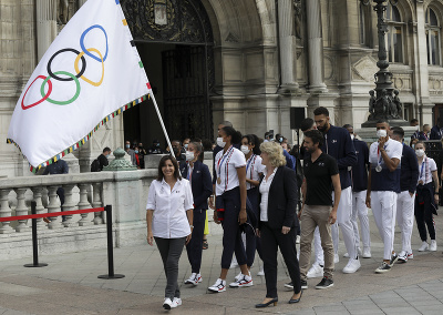 Starostka Paríža Anne Hidalgová  sa usmieva, keď prichádza s olympijskou vlajkou pred radnicu v Paríži