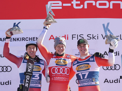 Švajčiarsky lyžiar Marco Odermatt ( v strede) oslavuje na pódiu svoj triumf v super-G alpských lyžiarov v Garmisch-Partenkirchene. 