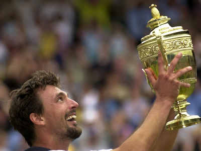 Víťaz grandslamového turnaja mužov vo Wimbledone, Chorvát Goran Ivaniševič, dvíha turnajovú trofej  po finálovom víťazstve nad Austrálčanom Patrickom Rafterom
