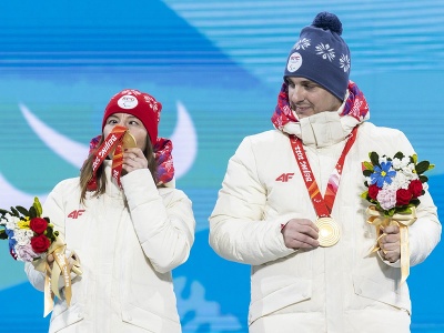 Slovenská reprezentantka v lyžovaní Henrieta Farkašová a navádzač Martin Motyka sa tešia na pódiu zo zisku zlatej medaily