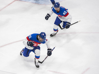 Na snímke slovenský hokejista Juraj Slafkovský (vľavo) sa teší po strelení úvodného gólu, vpravo Miloš Roman v zápase základnej C-skupiny Fínsko - Slovensko na ZOH 2022 v Pekingu