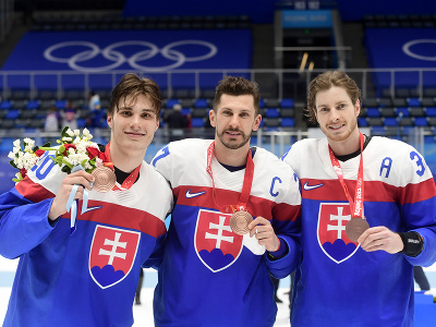 Na snímke slovenskí hokejisti zľava Juraj Slafkovský, Marek Hrivík a Peter Cehlárik oslavujú po zisku bronzu po zápase olympijského turnaja v hokeji mužov o bronz