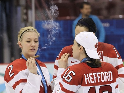 Kanadské hokejistky Jayna Heffordová (vpravo) a Meghan Agostová fajčia cigary na ľade po víťaznom zápase proti USA vo finále ženského hokejového turnaja na zimných olympijských hrách vo Vancouveri 25. februára 2010