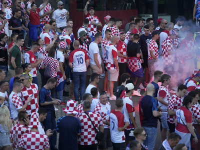 Fanúšikovia Chorvátska stoja v rade pred vchodom na štadión, zatiaľ čo na zemi horí svetlica, pred semifinálovým futbalovým zápasom Ligy národov medzi Holandskom a Chorvátskom na štadióne De Kuip v Rotterdame