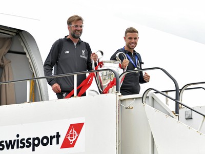 Tréner Liverpoolu Jürgen Klopp (vľavo) a Jordan Henderson držia trofej Ligy majstrov po prílete tímu na letisko Johna Lennona v Liverpoole