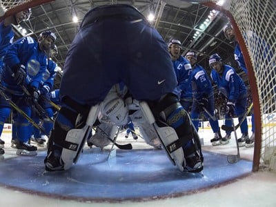 Kazašskí hokejisti stoja pred svojím brankárom
