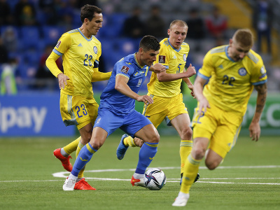 Ruslan Malinovskij sa snaží prejsť cez hráčov Kazachstanu 