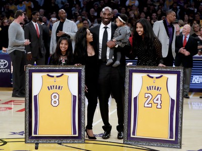 Bývalý hráč Los Angeles Laker Kobe Bryant pózuje so svojou rodinou počas vyvesenia svojich dvoch dresov v rámci zápasu zámorskej NBA