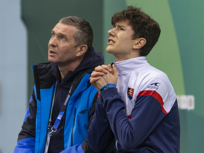 Na snímke slovenský krasokorčuliar Adam Hagara (vpravo) a tréner Vladimir Dvojnikov reagujú počas voľných jázd na zimných olympijských hrách mládeže 2024 v kórejskom Kangwone
