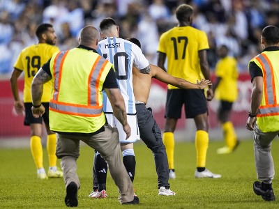 Na snímke usporiadatelia pacifikujú fanúšika, ktorý si chcel spraviť na ihrisku fotografiu s argentínskym Lionelom Messim