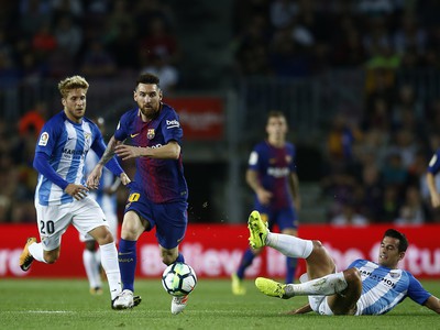 Lionel Messi bojuje s hráčmi Málagy o loptu