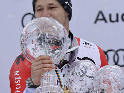 Švajčiarsky lyžiar Marco Odermatt oslavuje na pódiu s malým glóbusom za zjazd po tom, ako jury pre nepriaznivé podmienky zrušila finálový zjazd Svetového pohára alpských lyžiarov v rakúskom stredisku Saalbach
