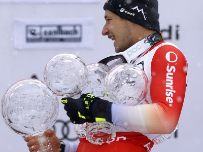 Švajčiarsky lyžiar Marco Odermatt oslavuje na pódiu s malým glóbusom za zjazd po tom, ako jury pre nepriaznivé podmienky zrušila finálový zjazd Svetového pohára alpských lyžiarov v rakúskom stredisku Saalbach