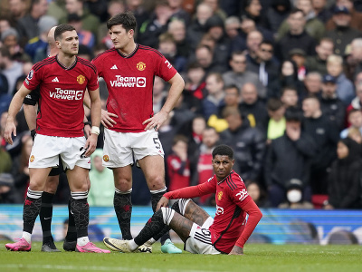 Zranený futbalista Manchestru United Marcus Rashford (vpravo) sedí na trávniku