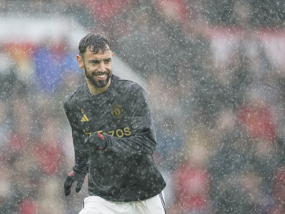 Futbalista Manchestru United Bruno Fernandes sa rozcvičuje počas hustého dažďa pred zápasom