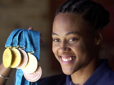 Na archívnej snímke z 1. októbra 2000 v Sydney americká atlétka Marion Jonesová ukazuje svojich päť olympijských medailí.