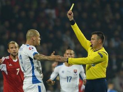 Druhý zľava Martin Škrtel (Slovensko) dostáva žltú kartu v kvalifikačnom zápase C - skupiny o postup na EURO 2016  Slovensko - Bielorusko v Žiline
