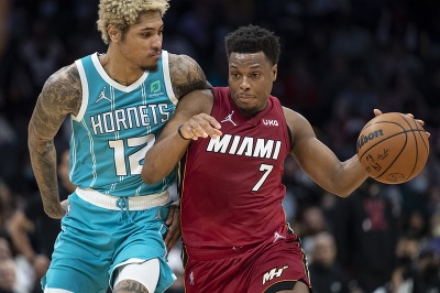 Basketbalista Miami Heat Kyle Lowry a hráč Charlotte Hornets Kelly Oubre Jr. bojujú o loptu
