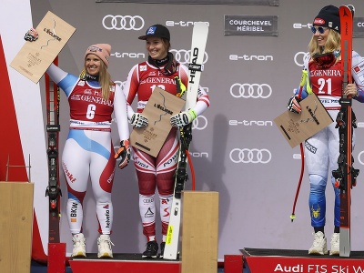Americká lyžiarka Mikaela Shiffrinová (vpravo) sa teší na pódiu z víťazstva vo finálovom zjazde Svetového pohára vo francúzskom dejisku Courchevel/Meribel 16. marca 2022. Druhé miesto obsadili Rakúšanka Christina Scheyerová a Švajčiarka Joana Hählenová (vľavo). 