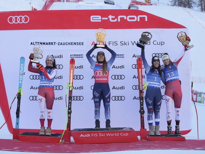 Uprostred talianska lyžiarka Sofia Goggiová oslavuje na pódiu víťazstvo v zjazde Svetového pohára v rakúskom Altemarkt-Zauchensee, vľavo druhá Rakúšanka Stephanie Venierová, vpravo tretia jej krajanka Mirjam Puchnerová.