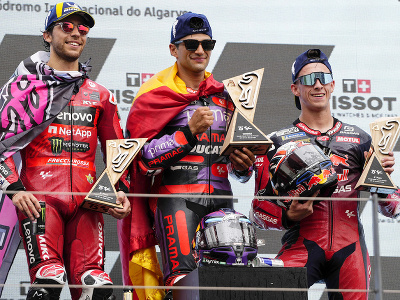 Víťazný španielsky motocyklista Jorge Martin (uprostred) oslavuje na pódiu s trofejou spoločne s druhým Talianom Eneom Bastianinim (vľavo) a tretím krajanom Pedrom Acostom (vpravo) po pretekoch na Veľkej cene Portugalska seriálu MotoGP na okruhu Algarve