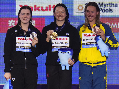 Víťazná plavkyňa z Hongkongu Siobhan Haugheyová (uprostred) pózuje na pódiu so zlatou medailou spolu so striebornou Novozélandčankou Erikou Jane Fairweatherovou (vľavo) a bronzovou Austrálčankou Briannou Throssellovou (vpravo) 