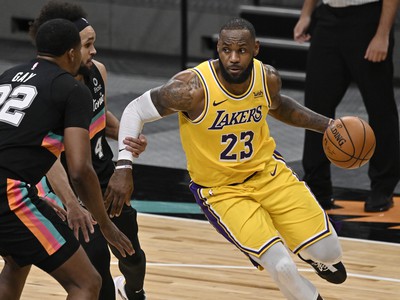 LeBron James vedie loptu cez dvoch hráčov Spurs