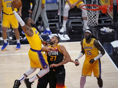Hráč Los Angeles Lakers  LeBron James (vľavo) strieľa na kôš cez Rudyho Goberta z Utahu Jazz